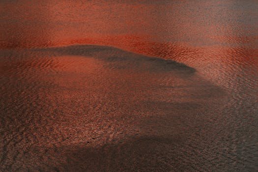 Red-tinted water surface with ripples creating a serene abstract pattern.